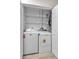 Laundry closet featuring a white washer and dryer, shelves, and modern fixtures at 1409 57Th W St # 1409, Bradenton, FL 34209