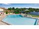 Community pool with nearby lake, pavilion, lounge chairs, and lush landscaping at 1409 57Th W St # 1409, Bradenton, FL 34209