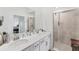 This bathroom features double sinks, a large mirror, white cabinets and a glass enclosed shower at 14257 Heritage Landing Blvd # 1122, Punta Gorda, FL 33955