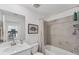 This bathroom features a single sink, a large mirror, white cabinets, and tiled tub with shower at 14257 Heritage Landing Blvd # 1122, Punta Gorda, FL 33955