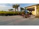 Patio with tables and chairs under blue umbrellas, perfect for outdoor dining and relaxation at 14257 Heritage Landing Blvd # 1122, Punta Gorda, FL 33955