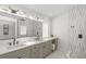 Bright bathroom featuring double sinks, sleek fixtures, and modern geometric shower tiling at 1527 Buoy Ln, Osprey, FL 34229