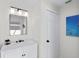 Bathroom features an elegant marble vanity, modern lighting, and an adjacent door with sleek black hardware at 1527 Buoy Ln, Osprey, FL 34229