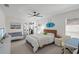Bright bedroom features a modern design with a cozy bed, a desk and a surf decor detail at 1527 Buoy Ln, Osprey, FL 34229