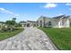 Inviting single-story home with a stone-paved driveway, lush green lawn and picturesque landscaping at 1527 Buoy Ln, Osprey, FL 34229