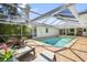 Serene screened-in pool area featuring lounge chairs for relaxing and a lush tropical landscape, perfect for outdoor enjoyment at 1527 Buoy Ln, Osprey, FL 34229
