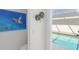 Inviting view into pool area featuring an artistic sea turtle graphic and lush planted greenery decorating the interior walls at 1527 Buoy Ln, Osprey, FL 34229