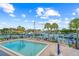 Community pool overlooking the marina and docks, surrounded by lounge chairs and palm trees at 1527 Buoy Ln, Osprey, FL 34229