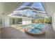 Beautiful screened-in pool with a hot tub, an inviting seating area, and seamless indoor-outdoor living spaces at 1527 Buoy Ln, Osprey, FL 34229