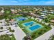 Aerial view of the community tennis courts with pristine landscaping and clear blue skies at 1527 Buoy Ln, Osprey, FL 34229