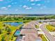 Aerial view of houses in a community featuring beautiful landscaping and a lake view at 17547 Cantarina Cv, Bradenton, FL 34211