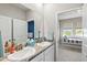 Light-filled bathroom with double sinks, granite countertops, and a view into an adjacent bedroom at 17547 Cantarina Cv, Bradenton, FL 34211