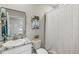 Bathroom with a granite vanity top, framed mirror, and patterned shower curtain at 17547 Cantarina Cv, Bradenton, FL 34211
