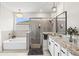 Luxurious bathroom featuring a soaking tub, glass-enclosed shower, and granite countertop vanity with modern fixtures at 17547 Cantarina Cv, Bradenton, FL 34211