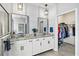 Elegant bathroom with double sinks, granite countertops, framed mirrors, and walk-in closet at 17547 Cantarina Cv, Bradenton, FL 34211