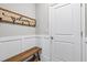 Entryway with a wood bench, coat hooks, and wainscotting at 17547 Cantarina Cv, Bradenton, FL 34211