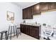 Kitchenette featuring rich dark cabinetry, modern countertops, and bar seating at 17547 Cantarina Cv, Bradenton, FL 34211