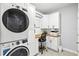 Functional laundry room with stacked washer and dryer, workspace, and storage at 17547 Cantarina Cv, Bradenton, FL 34211