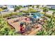 Aerial view of colorful community playground with slides, swings, and covered seating area at 17547 Cantarina Cv, Bradenton, FL 34211
