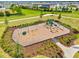 Aerial view of a well-maintained community playground with various play structures and landscaping at 17547 Cantarina Cv, Bradenton, FL 34211