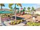 A cheerful neighborhood playground featuring picnic tables, slides, and swings under a bright, sunny sky at 17547 Cantarina Cv, Bradenton, FL 34211