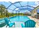 The screened pool area features clear blue water, a spa, and plenty of space for relaxing and entertaining at 17547 Cantarina Cv, Bradenton, FL 34211