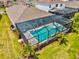 Aerial view of a beautiful screened-in pool, surrounded by lush landscaping, in a private backyard at 17547 Cantarina Cv, Bradenton, FL 34211