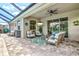 Enjoy outdoor living on this patio with ample seating, a grill, and views of the pool and lush surroundings at 17547 Cantarina Cv, Bradenton, FL 34211