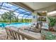 Relaxing screened-in patio with a gorgeous pool, seating area, and a picturesque view of the surrounding landscape at 17547 Cantarina Cv, Bradenton, FL 34211