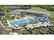 Overhead view of community center with tennis courts, swimming pools, palm trees, and parking at 17547 Cantarina Cv, Bradenton, FL 34211