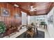 Charming dining room featuring wood paneled walls, a ceiling fan and a glass door entry at 2105 19Th W St, Bradenton, FL 34205