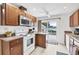 Cozy kitchen features wood cabinets, white appliances, and a sliding glass door to the deck at 2105 19Th W St, Bradenton, FL 34205