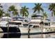 Waterfront property featuring boat docks and a glimpse of luxurious yachts under a bright blue, cloud-strewn sky at 2105 19Th W St, Bradenton, FL 34205