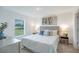 Comfortable bedroom with a plush bed, modern décor, and a window overlooking a green space at 23327 Van Buren Ave, Punta Gorda, FL 33980