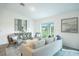 Open living room area with contemporary decor, neutral tones, and sliding glass doors to the backyard at 23440 Avacado Ave, Punta Gorda, FL 33980