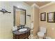 Well-lit bathroom with dark granite vanity, framed mirror, framed art, and toilet at 2726 Desoto Rd, Sarasota, FL 34234
