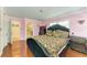 Bedroom featuring an ensuite bathroom, pink walls, wood floors, and luxurious bed at 2726 Desoto Rd, Sarasota, FL 34234