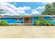 Bright blue home with stone accents, a tile entryway, and lush landscaping at 2726 Desoto Rd, Sarasota, FL 34234