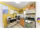 Bright, yellow kitchen with stainless steel appliances and efficient storage solutions, ready for cooking at 2726 Desoto Rd, Sarasota, FL 34234