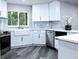 Bright kitchen featuring white cabinets, stainless appliances, a farmhouse sink and a view of the trees outside at 27944 Green Willow Run, Wesley Chapel, FL 33544