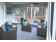 Inviting sunroom featuring neutral toned furniture, blue cushions, and tranquil wooded views at 27944 Green Willow Run, Wesley Chapel, FL 33544