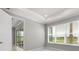 Bright bedroom featuring tray ceiling, large windows with outdoor views, and access to an outdoor patio at 3204 Torta Ct, Bradenton, FL 34211