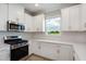 Modern kitchen featuring white cabinets, stainless appliances, and tile backsplash at 3204 Torta Ct, Bradenton, FL 34211
