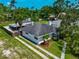 Aerial view of a single-story home with a well-manicured lawn, lush landscaping, and a detached garage at 326 25Th W St, Bradenton, FL 34205