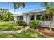 Beautiful white home with dark trim, manicured landscaping, and a decorative iron porch covering the entry at 326 25Th W St, Bradenton, FL 34205