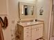 Bright bathroom featuring a framed mirror above a beige vanity with sink and ample storage at 3407 Avenida Madera # A, Bradenton, FL 34210