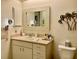 Bathroom with white vanity, mirror, and decorative palm tree wall art with view of toilet at 3407 Avenida Madera # A, Bradenton, FL 34210