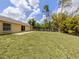 Spacious backyard features healthy green grass with a patio area and privacy fence at 3698 N Chamberlain Blvd, North Port, FL 34286