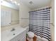 This bathroom features a mirror over the sink and a tub with a striped shower curtain at 3698 N Chamberlain Blvd, North Port, FL 34286