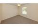 This simple bedroom is carpeted and features a ceiling fan and a window overlooking a fenced yard at 3698 N Chamberlain Blvd, North Port, FL 34286